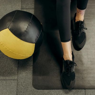 Close-up on athletic shoes on a gym floor, symbolizing stability.